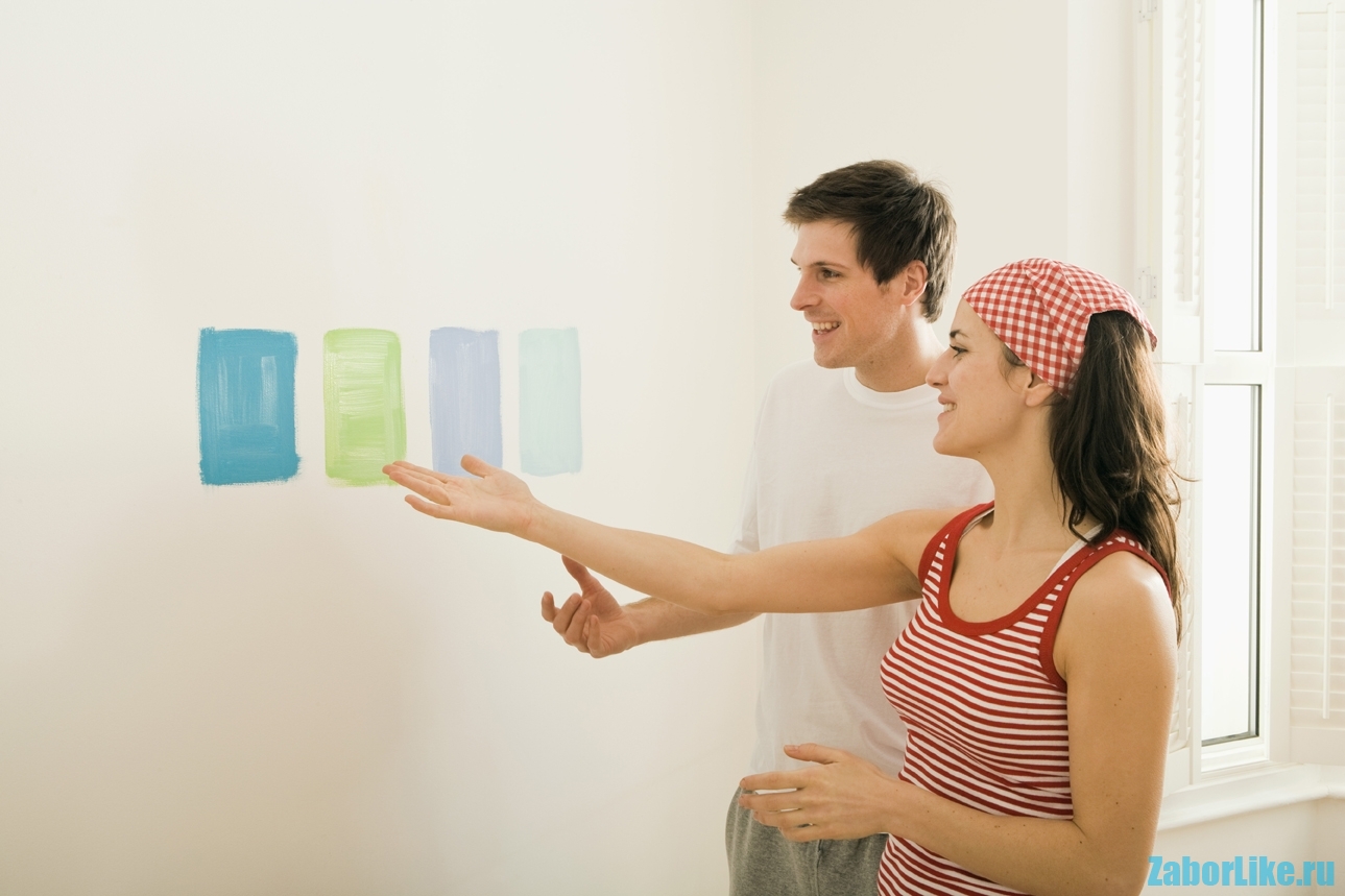 Couple choosing color swatches on wall